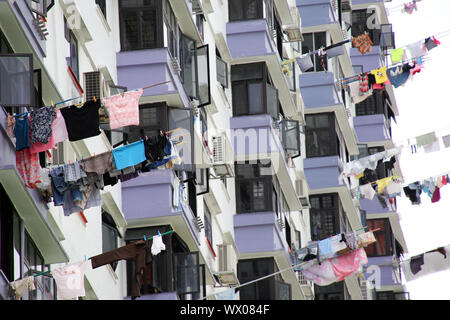 Il grattacielo residenziale, servizio lavanderia appesi su pali di asciugare fuori dalla finestra Foto Stock