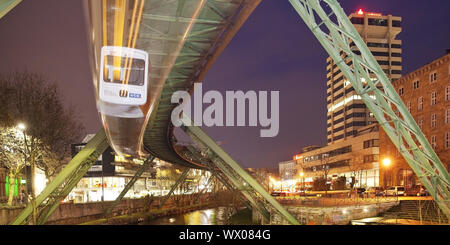 Stazione ferroviaria in sospensione in movimento sul fiume Wupper di notte, Wuppertal, Germania, Europa Foto Stock