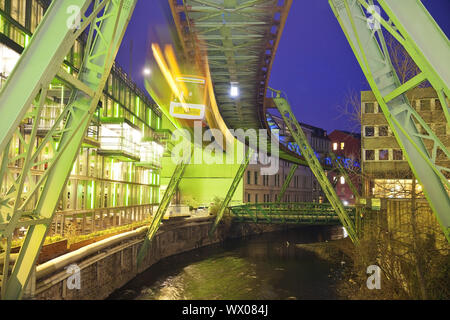 Stazione ferroviaria in sospensione in movimento sul fiume Wupper di notte, Wuppertal, Germania, Europa Foto Stock