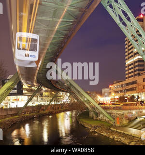 Stazione ferroviaria in sospensione in movimento sul fiume Wupper di notte, Wuppertal, Germania, Europa Foto Stock