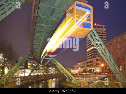 Stazione ferroviaria in sospensione in movimento sul fiume Wupper di notte, Wuppertal, Germania, Europa Foto Stock