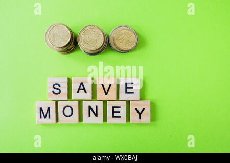 Il futuro della finanza, business banking e concetto finanziario. Flatlay centesimi di Euro e lettere di cubi di risparmiare sui costi di colore verde dello sfondo. Selective fo Foto Stock