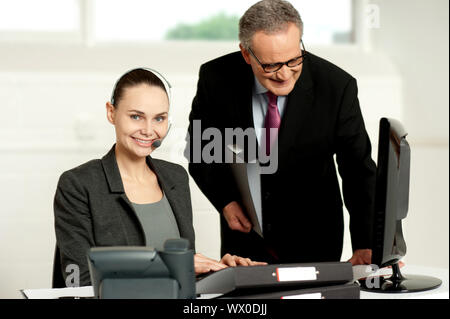 Team di due dirigenti aziendali che lavorano in ufficio nella parte anteriore del computer Foto Stock