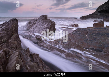 Sovracorrente onde intorno alle rocce frastagliate su Wildersmouth Beach, Ilfracombe, Devon, Inghilterra, Regno Unito, Europa Foto Stock