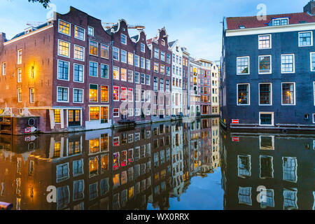 Vecchi edifici a capanna da un canale al tramonto, Oudezijds Kolk, Amsterdam, Olanda Settentrionale, Paesi Bassi, Europa Foto Stock