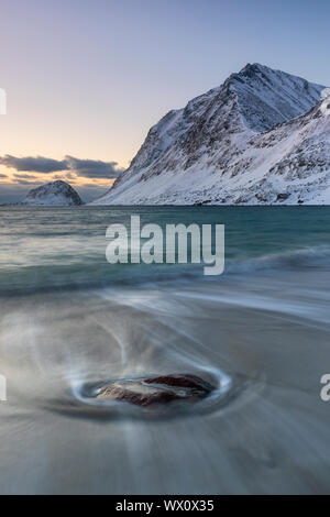 Pietra solitaria sulla spiaggia Haukland in inverno, Lofoten, Nordland, artiche, Norvegia, Europa Foto Stock