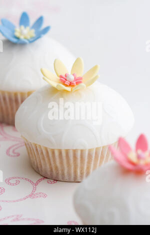 Tortine decorate con fondente goffrato e fiori di zucchero Foto Stock