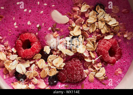 Close-up di frullati con frutti di bosco, fiocchi d'avena e semi di lino. Una sana prima colazione Foto Stock