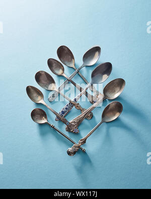 Set di posate di argento cucchiaio cucchiaio e cucchiaino isolato su blu Foto Stock