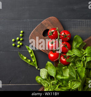 Composizione con un assortimento di materie organiche e di verdure hearbs nero su sfondo di legno. Foto Stock