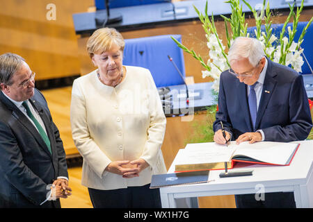 Bonn, Germania. Xvi Sep, 2019. Klaus Töpfer (r, CDU), ex Ministro federale dell'ambiente, si unisce il Cancelliere federale Angela Merkel (CDU) e Armin Laschet (CDU), il primo ministro del Land Renania settentrionale-Vestfalia, nella firma il libro degli ospiti nel corso della cerimonia di premiazione del Premio di Stato del Land Renania settentrionale-Vestfalia nella vecchia sala plenaria. Potter è onorato con il premio più alto della Renania settentrionale-Vestfalia. Credito: Rolf Vennenbernd/dpa/Alamy Live News Foto Stock