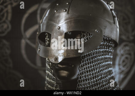 Casco di viking warrior con mail su stemma con disegni e viking simbolismo, arte tradizionale del nord Europa, confl Foto Stock
