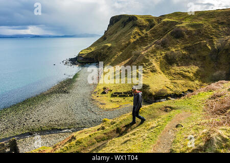 Un viandante scendendo il Sentiero per la lealt Gorge a Inver Tote, Trotternish, Isola di Skye, Scotland, Regno Unito Foto Stock