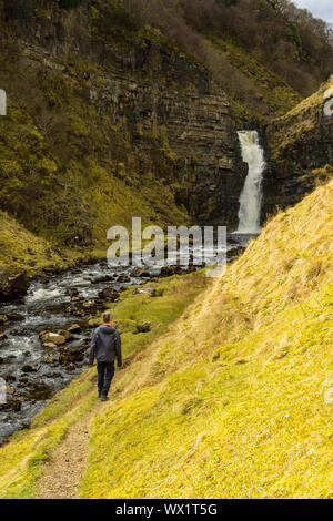 Un viandante si avvicina la lealt inferiore la cascata nel Lealt Gorge, Trotternish, Isola di Skye, Scotland, Regno Unito Foto Stock