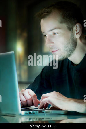 Giovane uomo con il computer portatile Foto Stock