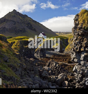 Casa sulla costa di basalto off Stapafell montagna, Arnarstapi, Snaefellsnes, Islanda, Europa Foto Stock