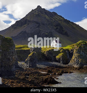 Casa sulla costa di basalto off Stapafell montagna, Arnarstapi, Snaefellsnes, Islanda, Europa Foto Stock