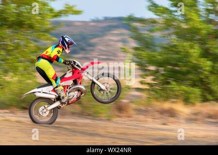 Il pilota di Motocross facendo un'impennata Foto Stock