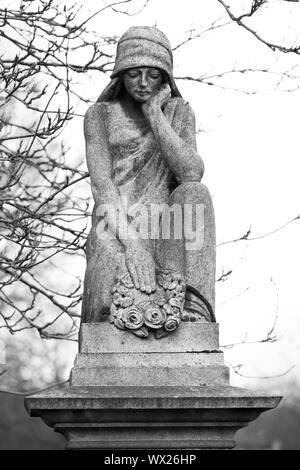 Statua che ornano la parte superiore di una lastra tombale Foto Stock