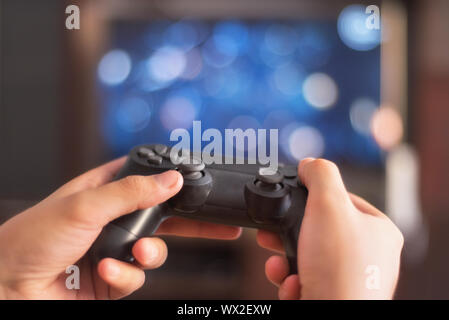 Man tenere un game pad nella parte anteriore dello schermo tv Foto Stock