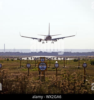 In aereo in atterraggio, attraversare la galleria del vento in pista con le luci di posizione, Koeln-Bonn aeroporto, Germania Foto Stock