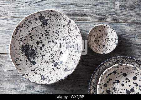 Ceramiche decorative - bocce, piastre ricoperte con smaltati in grigio sullo sfondo di legno. Vista superiore della tradizione artigianale a. Foto Stock