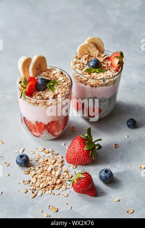 Prepered colazione casalinga di sani ingredienti naturali - Fiocchi di avena, fette di banana, yogurt su un cemento grigio Sfondo. Foto Stock