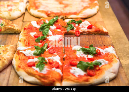 Molte fette di pizza sul tavolo di legno Foto Stock