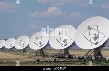 Molti white parabole satellitari tutti in riga nella scintillante deserto di calore Foto Stock
