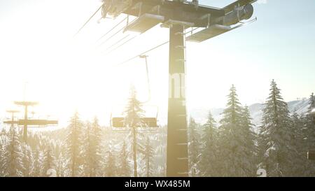 Svuotare ski lift. seggiovia silhouette sulla montagna alta sopra la foresta al tramonto Foto Stock