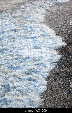 Il mare surf su una spiaggia di ciottoli. Lyme Regis. Inghilterra Foto Stock