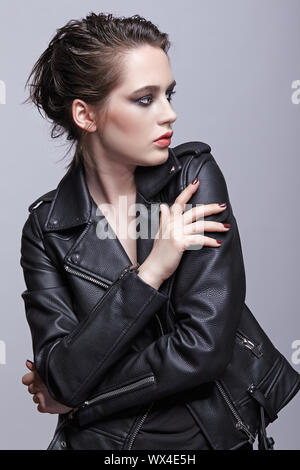 Ritratto di donna in nero giacca in pelle. Donna con inusuale bellezza sera trucco e Viola - Nero ombre make-up. Foto Stock