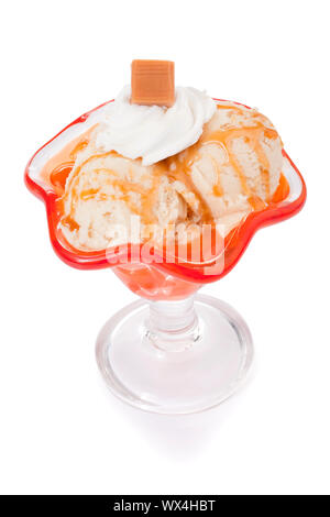 Tazza di caramello gelato decorate con panna montata e caramello chunk su uno sfondo bianco Foto Stock