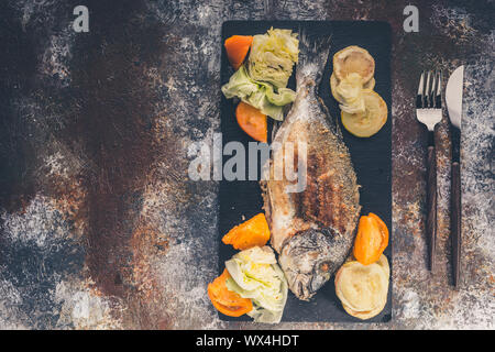 Dorada grigliata di pesce con verdure close-up. Vista dall'alto. Spazio di copia Foto Stock