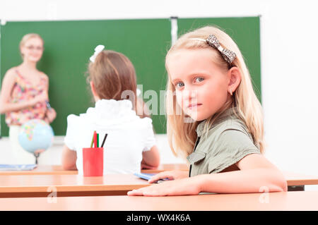 Ritratto della ragazza in classe, il Maestro dice al prossimo Consiglio scolastico Foto Stock