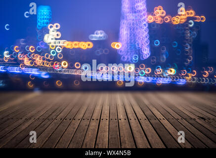 Piattaforma di legno e le luci della città di notte Foto Stock