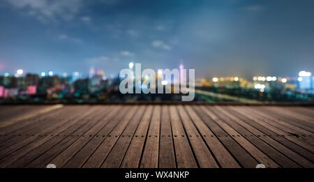 Piattaforma di legno e le luci della città di notte Foto Stock