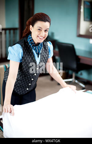 Bella sorridente attendant holding foglio, rifare la camera dopo i clienti check-out Foto Stock