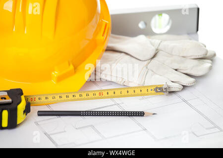 Hardhat guanti e degli strumenti di misurazione sul blueprint Foto Stock