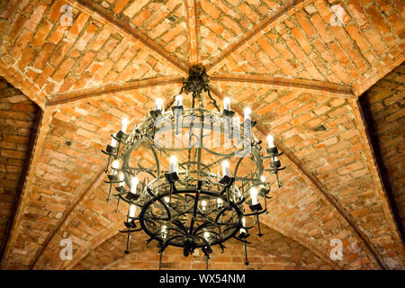 Il lampadario sul soffitto di mattoni in castello Foto Stock