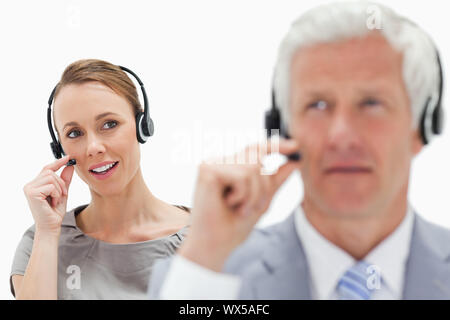 Donna Uomo sullo sfondo di fronte indossando un auricolare Foto Stock