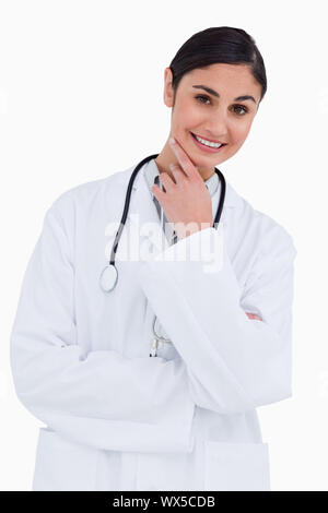 Donna sorridente medico in pensatori pongono contro uno sfondo bianco Foto Stock