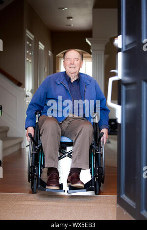 Anziani di 90 anni di vecchio uomo in sedia a rotelle al suo sportello anteriore Foto Stock