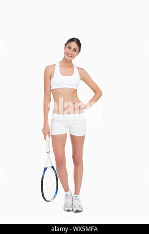 Slim brunette in posa con una racchetta da tennis contro uno sfondo bianco Foto Stock