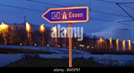 Segno di direzione di Essen sull'autostrada A40 in serata, Bochum, la zona della Ruhr, Germania, Europa Foto Stock