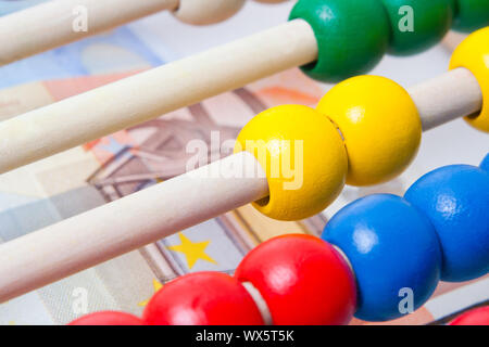 Il concetto di istruzione - Abacus con molte perle colorate e le banconote in background Foto Stock