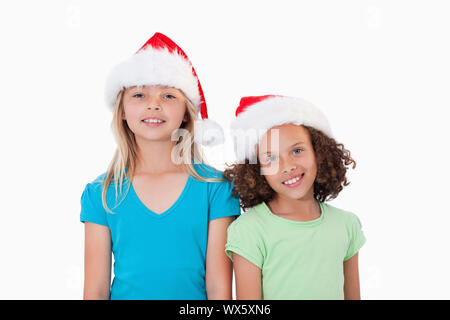 Le ragazze con cappelli di Natale contro uno sfondo bianco Foto Stock