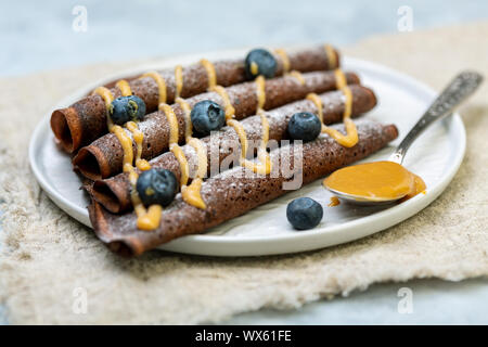 Crepes di cioccolato con caramello e zucchero a velo. Foto Stock