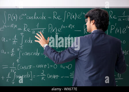 Giovane maschio insegnante di matematica in aula Foto Stock