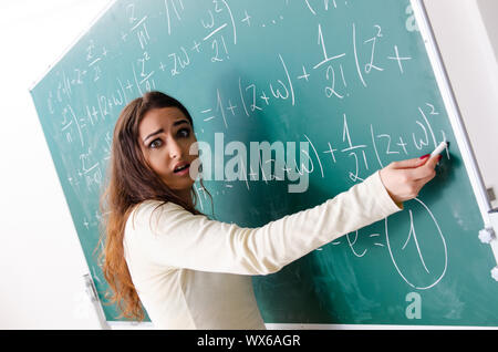 Femmina giovane insegnante di matematica di fronte a lavagna Foto Stock